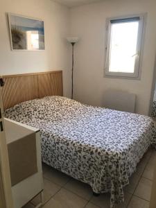 um quarto com uma cama e uma janela em Le Ciel Bleu em La Seyne-sur-Mer