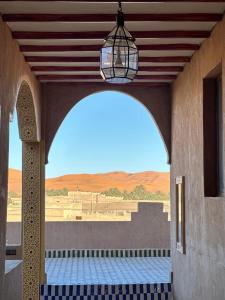 un arco con vista su un deserto da un edificio di Camels House a Merzouga