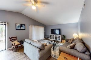 uma sala de estar com dois sofás e uma televisão em Island Retreat em St. George Island