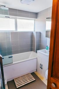 a bathroom with a tub and a toilet and a sink at Easy access to Cardiff City Centre & FREE Parking! in Cardiff