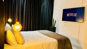um quarto de hotel com uma cama e uma televisão em Industrial CHIC Apartment 113 em Joanesburgo