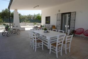 a white table and chairs in a living room at Casina Anna Maria in Francavilla Fontana
