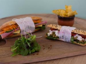 a sandwich and chips on a wooden cutting board at The Smugglers Rest in Woolacombe