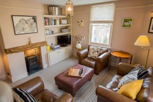 a living room with leather furniture and a fireplace at 3 Trinity Street in Southwold