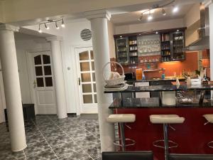 a bar in a restaurant with columns in a room at Kenézy Szállás in Hajdúszoboszló