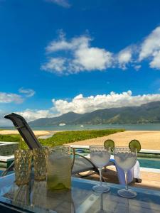 a glass table with wine glasses sitting on a balcony at Ágape Hotel in São Sebastião
