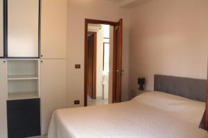 een slaapkamer met een wit bed en een kast bij mare, sole e relax a 5 km da Cefalu' in Cefalù