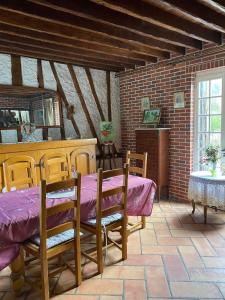 ein Zimmer mit einem Tisch, Stühlen und einer Ziegelwand in der Unterkunft Gîte les hortensias 