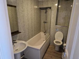 a bathroom with a tub and a toilet and a sink at The Menai Hotel and Bar in Bangor