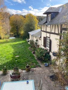 einen Außenblick auf ein Haus mit einem Tisch in der Unterkunft Gîte les hortensias 