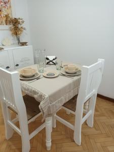 康科迪亞的住宿－Dos Ambientes Deluxe Concordia Centro，一张带两把椅子的白色桌子和一张白色的桌布