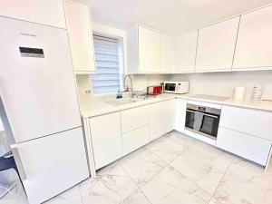 a white kitchen with white cabinets and appliances at Paradigm House, Luxury 2-Bedroom Apartment 3, Free Parking, Oxford in Oxford