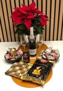 APARTAMENTS L’ARC في بالافروجيل: طاولة مع زجاجة من النبيذ و مزهرية مع الزهور الحمراء
