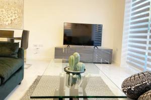 a living room with a couch and a tv at Paradigm House, Luxury 2-Bedroom Apartment 3, Free Parking, Oxford in Oxford