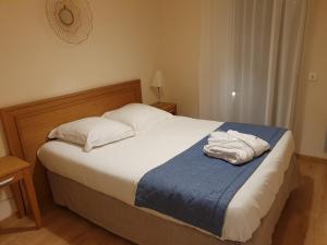 a bedroom with a bed with white sheets and pillows at Domitys Le Phare d'Argent in Cherbourg en Cotentin