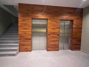2 ascensores en un edificio con paredes y escaleras de madera en Cozy apartment next to ice rink, en Gudauri