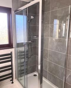 a shower with a glass door in a bathroom at 2 bed House with office in Historic Richmond in Richmond