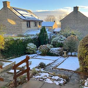 a snow covered garden with a bench in front of a house at 2 bed House with office in Historic Richmond in Richmond