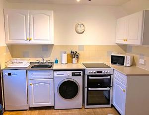 a kitchen with a washing machine and a microwave at 2 bed House with office in Historic Richmond in Richmond