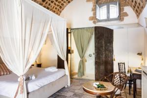a bedroom with a bed and a table with a tableasonable at Masseria Costanza, Vendicari Retreat in Noto