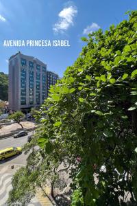 a large green tree in front of a building at Studio SOL de COPACABANA 300 m da Praia in Rio de Janeiro