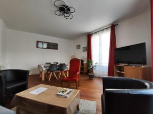 a living room with a tv and a table and chairs at Toul superbe appartement plein centre in Toul