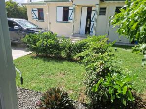una casa con un patio con plantas delante en An'Kanna en Petit-Bourg