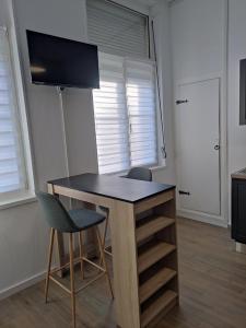 escritorio en una habitación con 2 sillas y ventana en Bienvenue chez Coco en Dunkerque