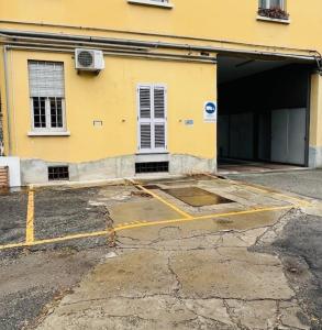 un aparcamiento vacío frente a un edificio en Via Breda 120, en Milán