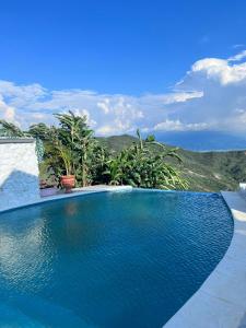 una piscina de agua azul y montañas de fondo en Lago Calima-Villa la Estrella, en Yotoco