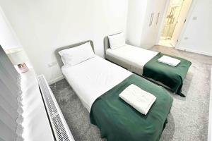 2 letti in una camera con lenzuola verdi di Paradigm House, Stunning 2-Bedroom Apartment 1, free Parking, Oxford a Oxford