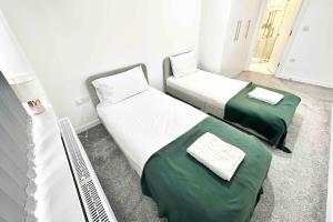 two beds in a room with green sheets at Paradigm House, Stunning 2-Bedroom Apartment 1, free Parking, Oxford in Oxford