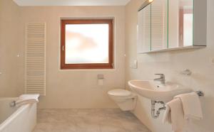 a bathroom with a sink and a toilet and a window at Stoanpeppelehof in Natz-Schabs +17 photos