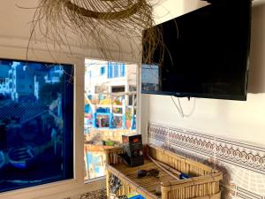 sala de estar con ventana grande y TV de pantalla plana en The Sea Guesthouse, en Agadir