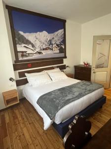 a bedroom with a large bed with a painting on the wall at Ca' Elide in Aosta