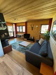 een woonkamer met een bank en een tafel bij Appartement T2 ambiance chalet centre village in La Clusaz