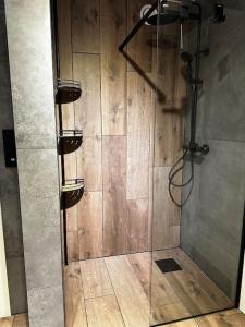 a shower with a glass door in a room at Familievennlig Apartment in Tvedestrand