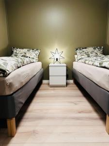 a bedroom with two beds and a night stand with a star at Familievennlig Apartment in Tvedestrand