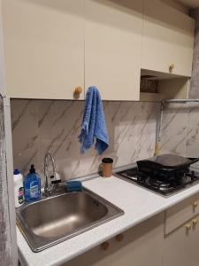a kitchen counter with a sink and a stove at Eminera Hostels Baku in Baku