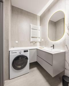 y baño con lavadora y lavamanos. en Aperto Apartament Gdynia centrum 10 piętro, en Gdynia