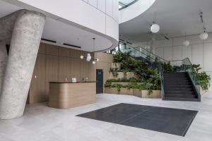 un vestíbulo con una escalera y un mostrador con plantas en Aperto Apartament Gdynia centrum 10 piętro, en Gdynia