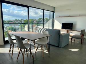 een woonkamer met een tafel en stoelen en een bank bij Hermoso departamento a estrenar in Mar del Plata