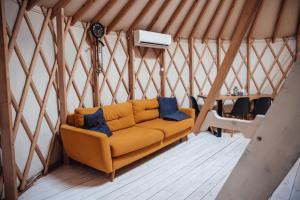 a couch in the middle of a yurt at Slow Flow Glamp in Rzyki