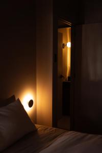 Cette chambre sombre dispose d'un lit et d'une lumière sur le mur. dans l'établissement Private Apartment - the coffee apartment, à Cusco
