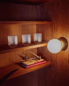 a shelf with glasses and a light and a book at Private Apartment - the coffee apartment in Cusco