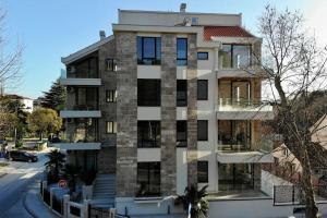 a tall white building with windows on a street at Park Residence 7 - 1 bd apartment in Tivat Center in Tivat
