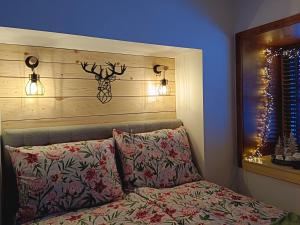 a bedroom with a bed with two pillows and lights at Berghof Reiter in Weissbriach