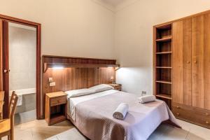 a bedroom with a large bed with a wooden headboard at Hotel Giada Roma in Rome