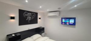 Habitación blanca con una foto de elefante en la pared en Home away from home!, en Yate