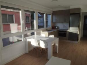 cocina con mesa blanca y sillas blancas en Apartamento Bulevar Cangas, en Cangas de Morrazo